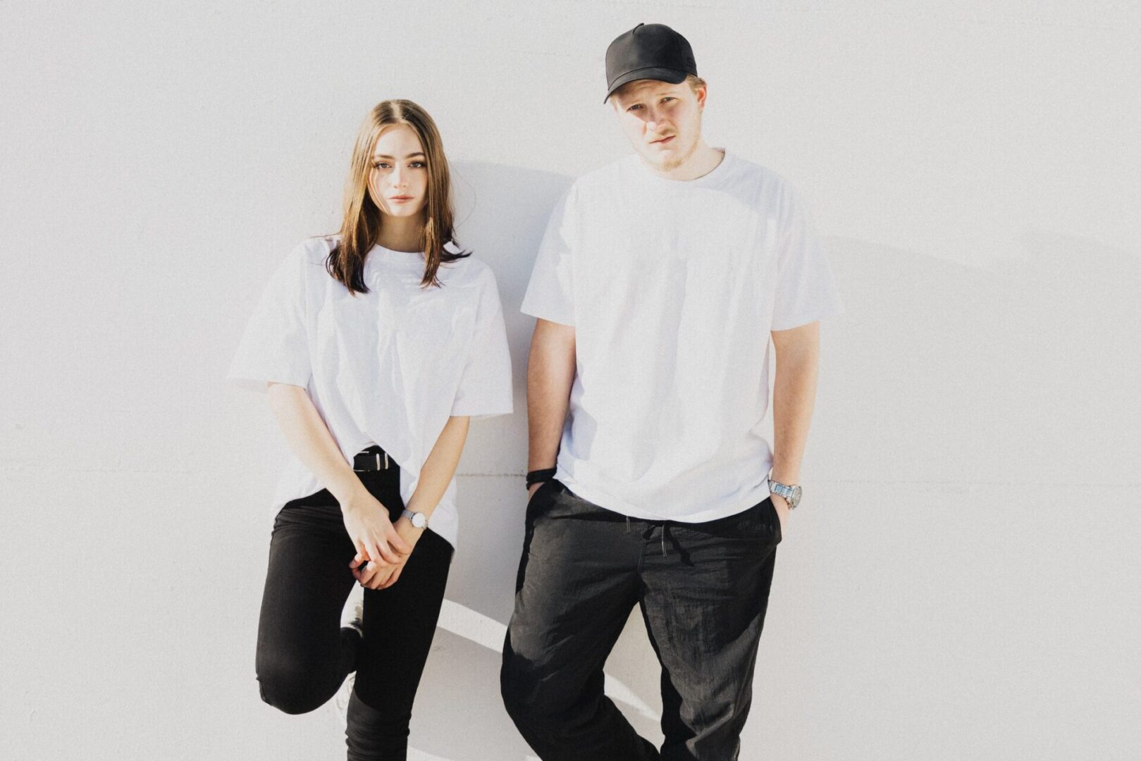 Two people in white shirts and caps.